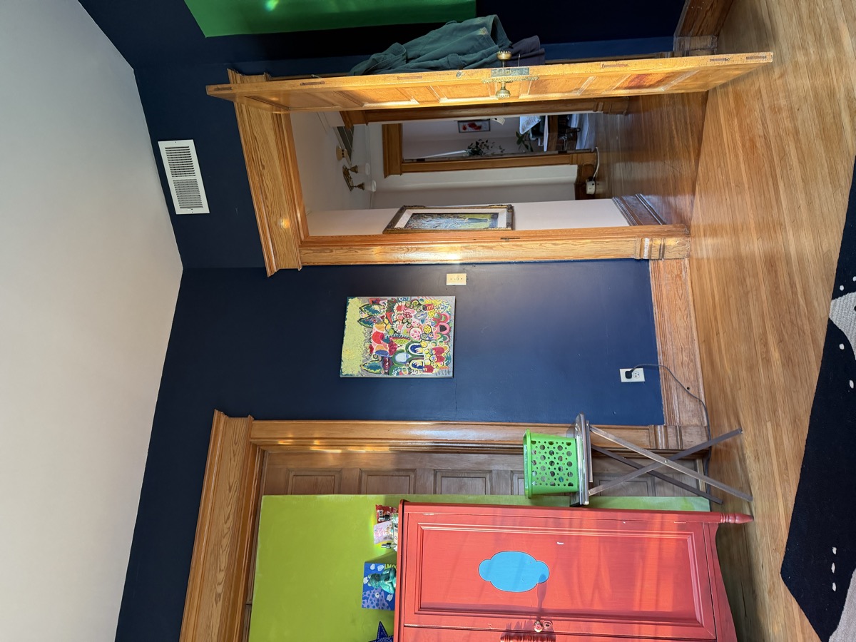 Warm navy walls with colorful art and oak woodwork