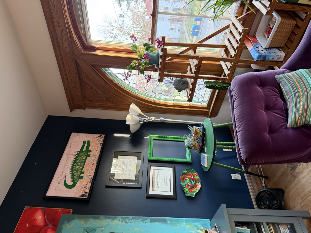 Stained glass window, purple velvet chair, diplomas and art